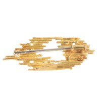 Architectural gold brooch by Andrew Grima with diamond accents and staggered openwork design