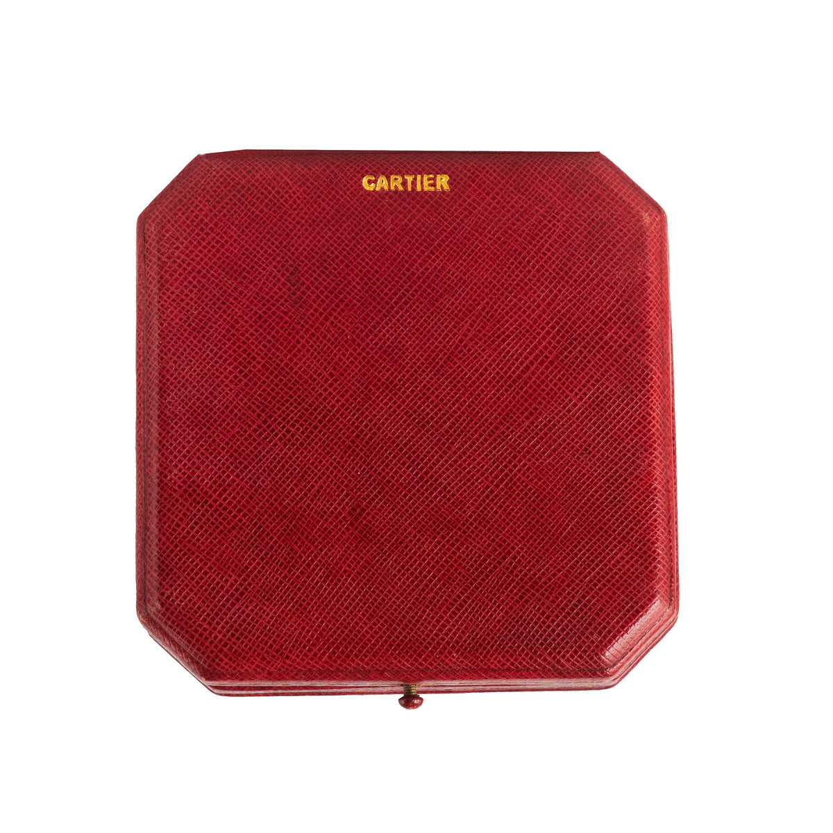 Top view of 1930s Cartier red leather brooch box with gold Cartier lettering and textured finish.