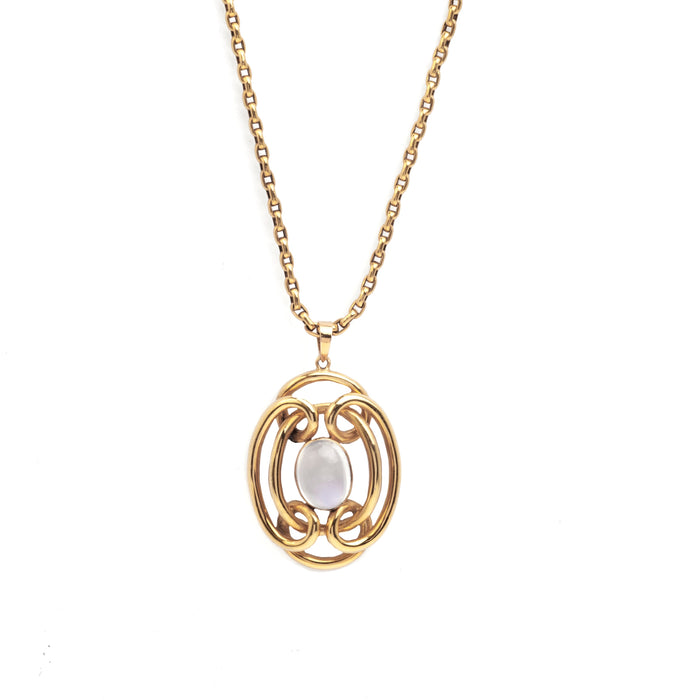 Art Nouveau 15ct gold pendant with openwork scroll design and central cabochon moonstone, shown on gold chain.