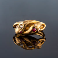 Front view of antique ruby and diamond snake ring on black background, 18ct gold c.1900.
