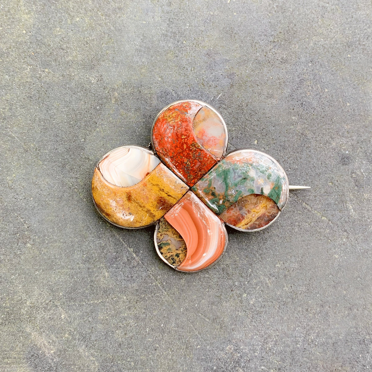 Front view of a Victorian Scottish agate and silver brooch c.1880 with interlaced circular design inlaid with colourful agates.