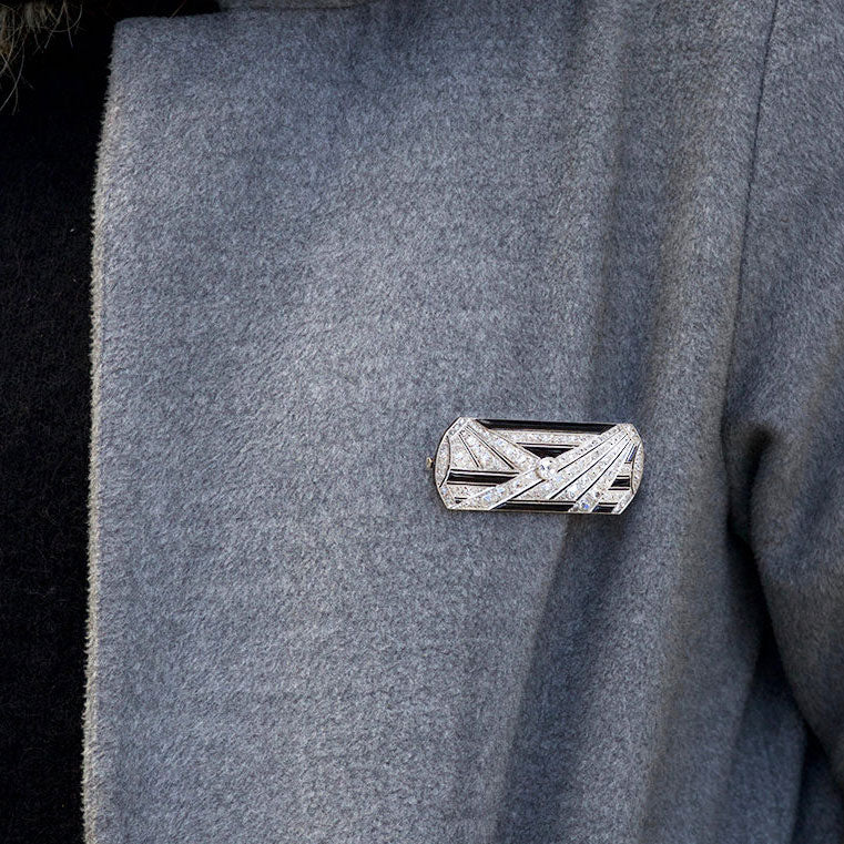 Elegant Art Deco diamond and onyx brooch from the 1920s shown worn, platinum setting and 5ct diamonds