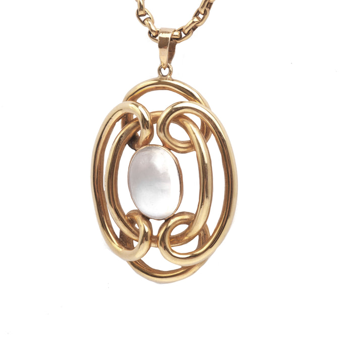 Close up of antique Art Nouveau pendant in 15ct gold, featuring a luminous oval moonstone in a flowing whiplash frame.