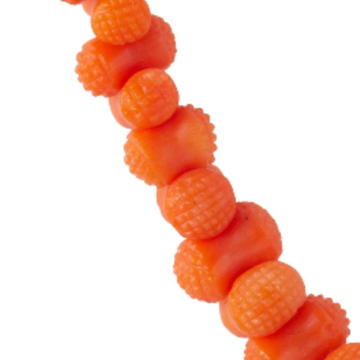 Close up detail of hand carved hobnail coral beads from an antique 1880s Italian necklace.