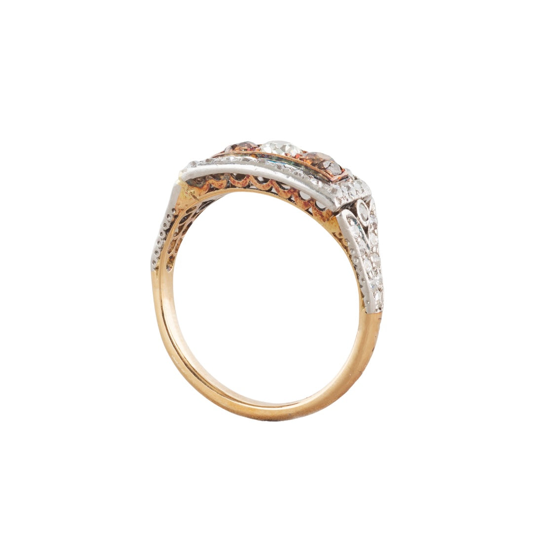 Side view of a 1910 Edwardian 18ct gold and platinum-topped ring, set with two cognac diamonds and old cut white diamonds in a rectangular plaque design.