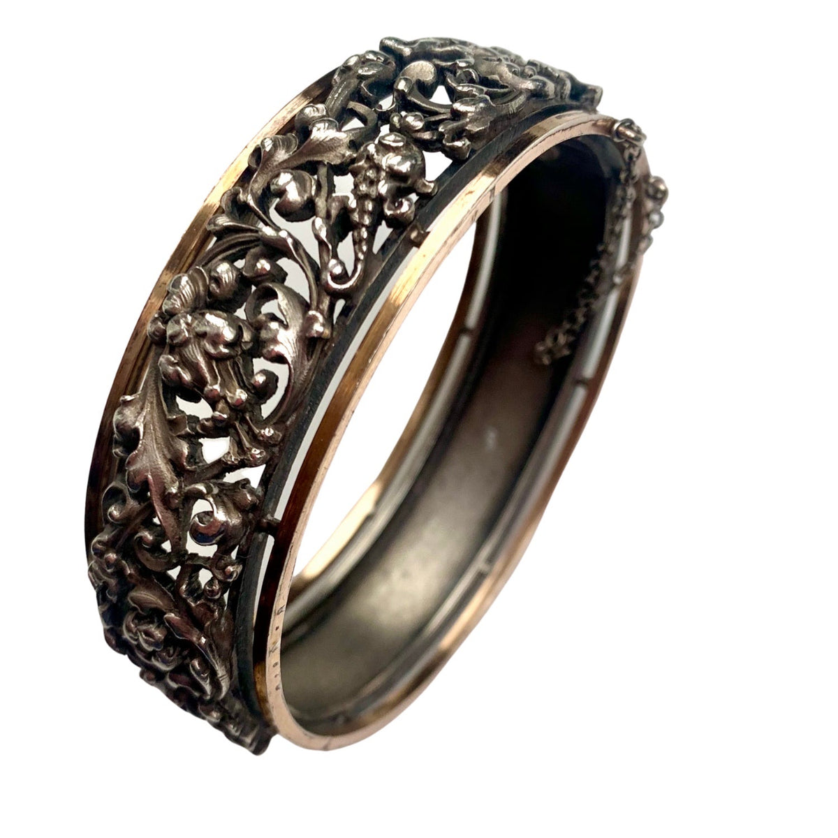 Open view of French Art Nouveau silver bangle with safety chain and silver gilt border details.