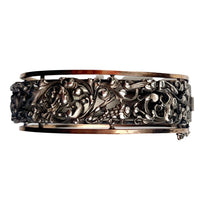 Front view of French Art Nouveau silver bangle, c.1890s, with pierced foliate motif and silver gilt borders.