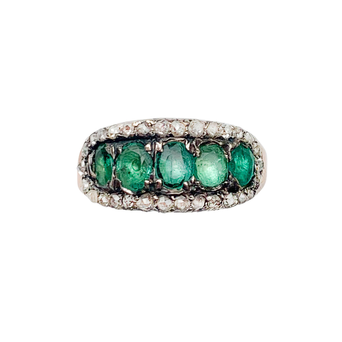 Front view of a late Georgian emerald and diamond ring c.1820, five emeralds framed by rose cut diamonds in silver and 18ct gold.