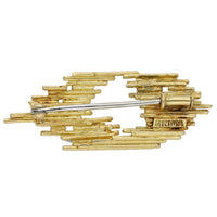 Architectural gold brooch by Andrew Grima with diamond accents and staggered openwork design