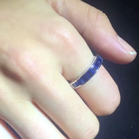 1970s half hoop sapphire ring in 18ct white gold with square-cut channel-set sapphires, shown on white background and worn on hand.