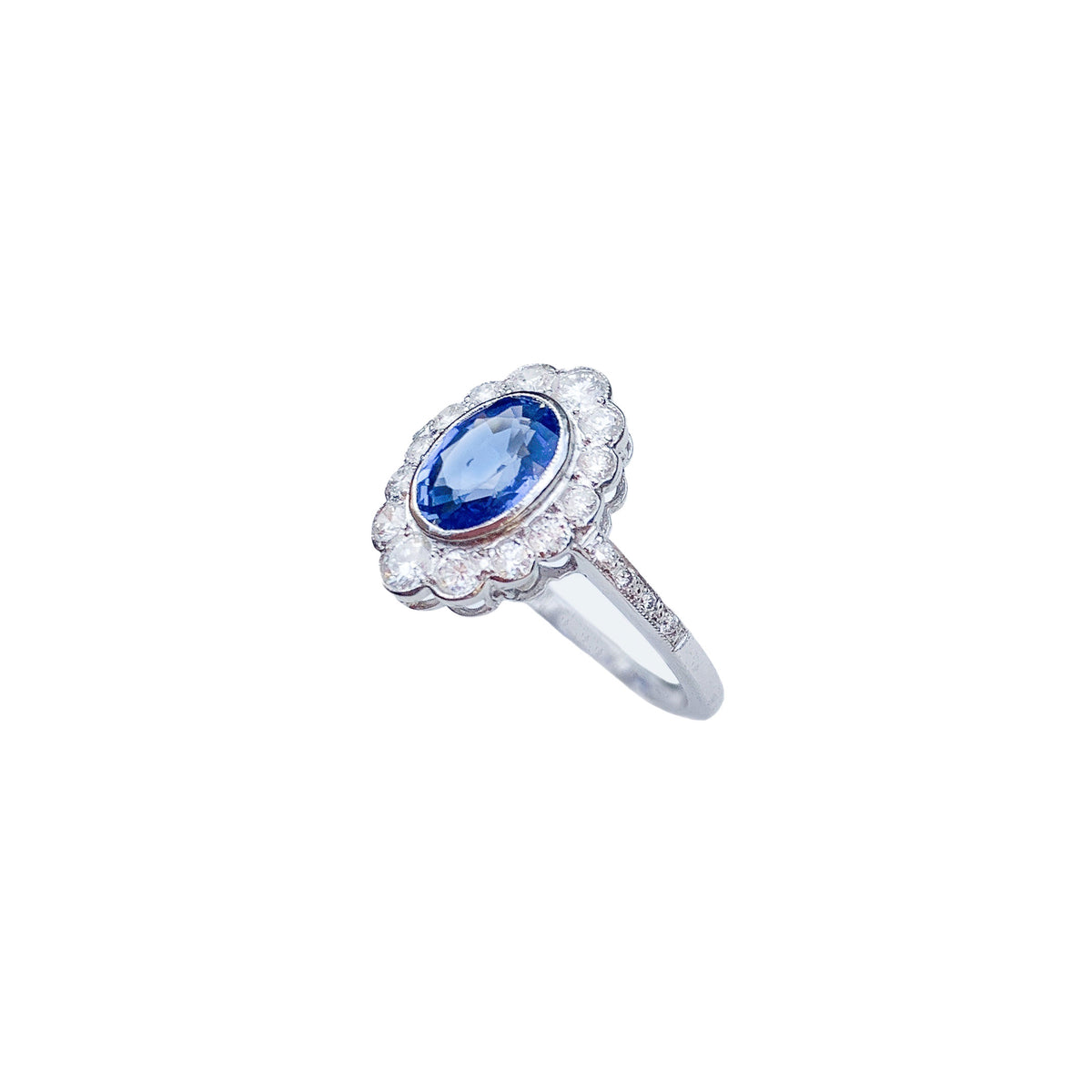 Side profile of a vintage 1960s sapphire and diamond ring in 18ct white gold showing the raised setting and scalloped halo