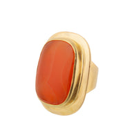 Front view of a Swedish 1950s statement ring crafted in 18ct gold, set with a large earthy orange red carnelian cabochon