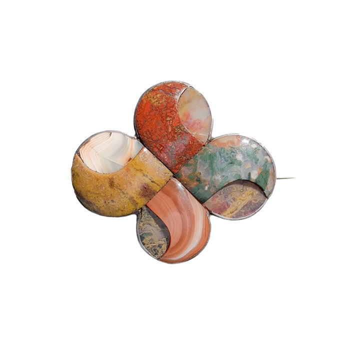 Antique Scottish brooch from the 1880s, silver mount with polished agates in a flowing interlaced circular pattern, front view.