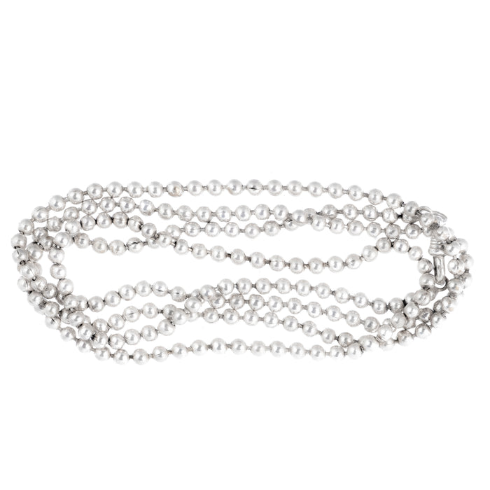 Coiled view of a Victorian silver ball necklace, English c.1880s, 110cm long strand of silver beads weighing 60g.