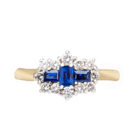 Front view of a vintage sapphire and diamond cluster ring, 18ct gold and platinum, set with three sapphires and a diamond halo, British c.1990s.