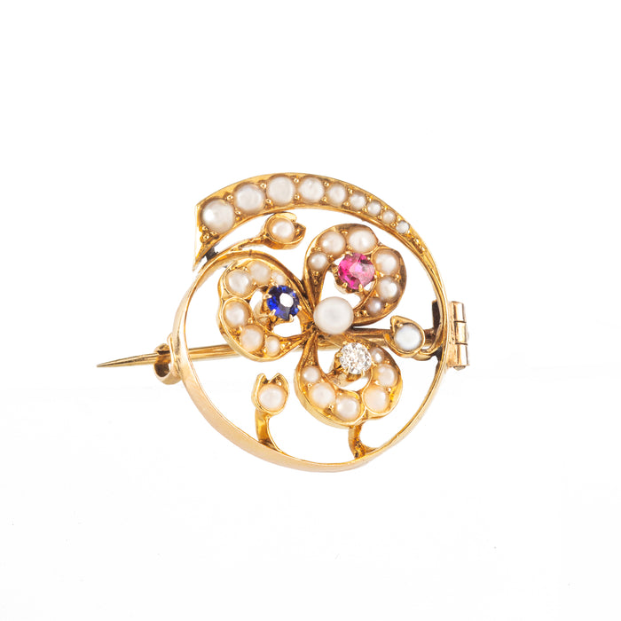 Three-leaf clover brooch in 18ct gold with ruby, sapphire, diamond, and pearls, c.1900–1910