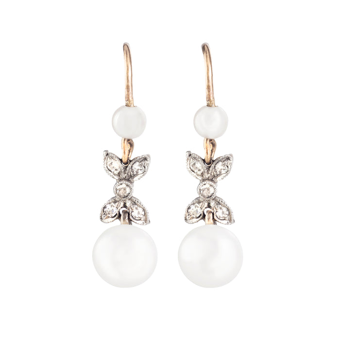 Edwardian pearl and diamond drop earrings with millegrain bow detail in gold and platinum