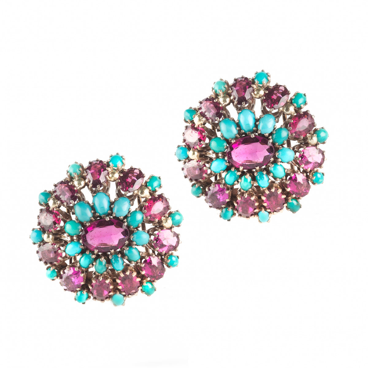 Front view of a pair of circular Art Deco dress clips by Dorrie Nossiter, set with pink garnets and turquoise in silver.