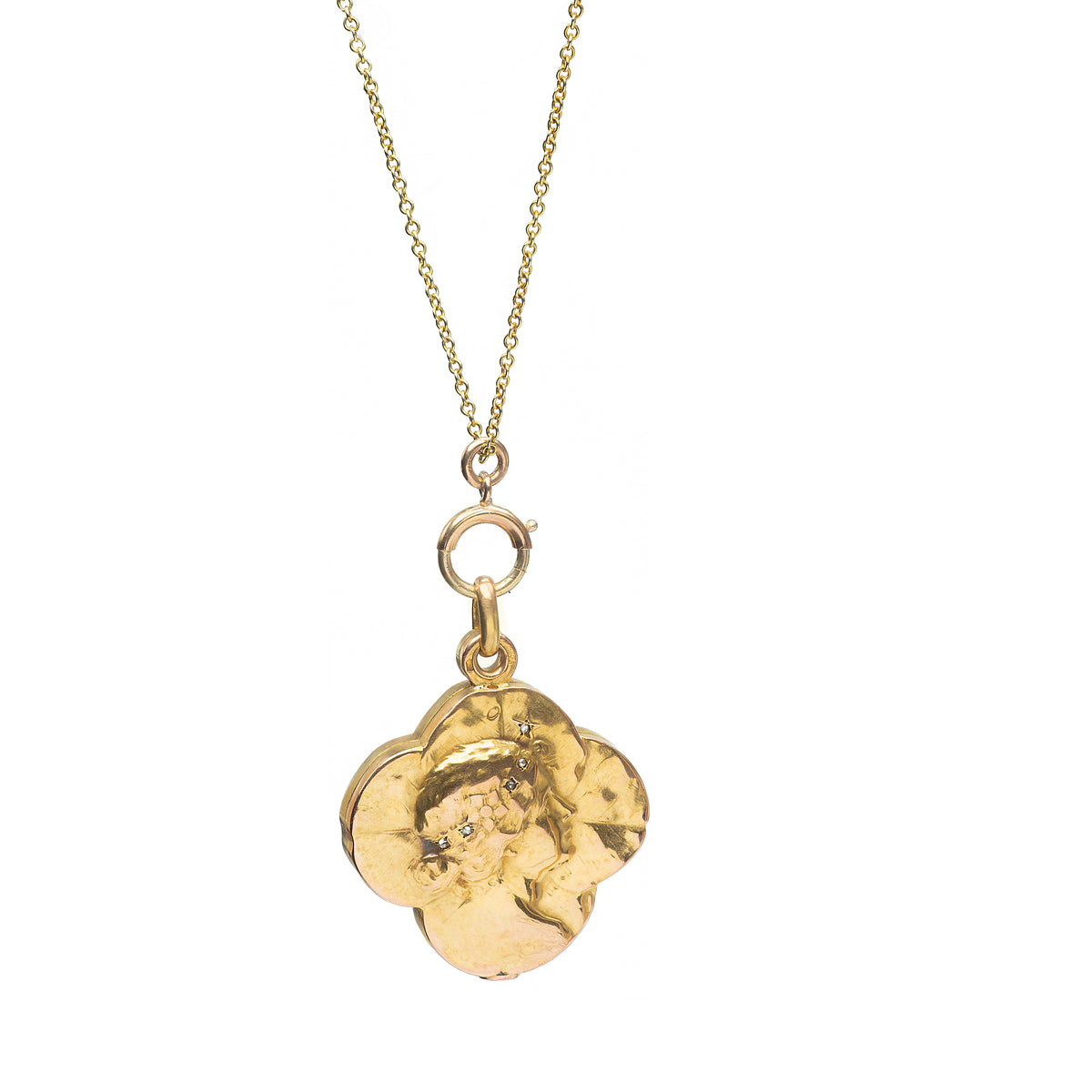 Art Nouveau French gold locket in the shape of a four-leaf clover with a sculpted female profile and small diamond accents, c.1910.