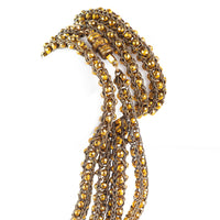 Close-up of braided textile and faceted Pinchbeck beads on a late Victorian sautoir