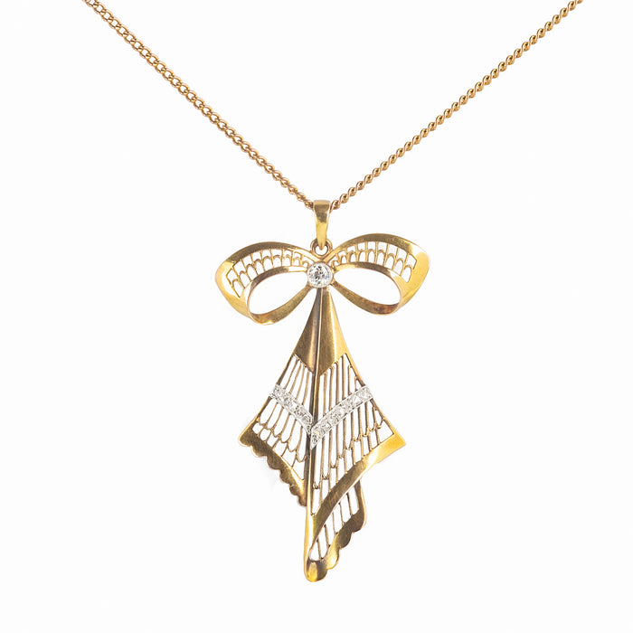 1960s German gold bow pendant necklace with openwork design and diamond accents.