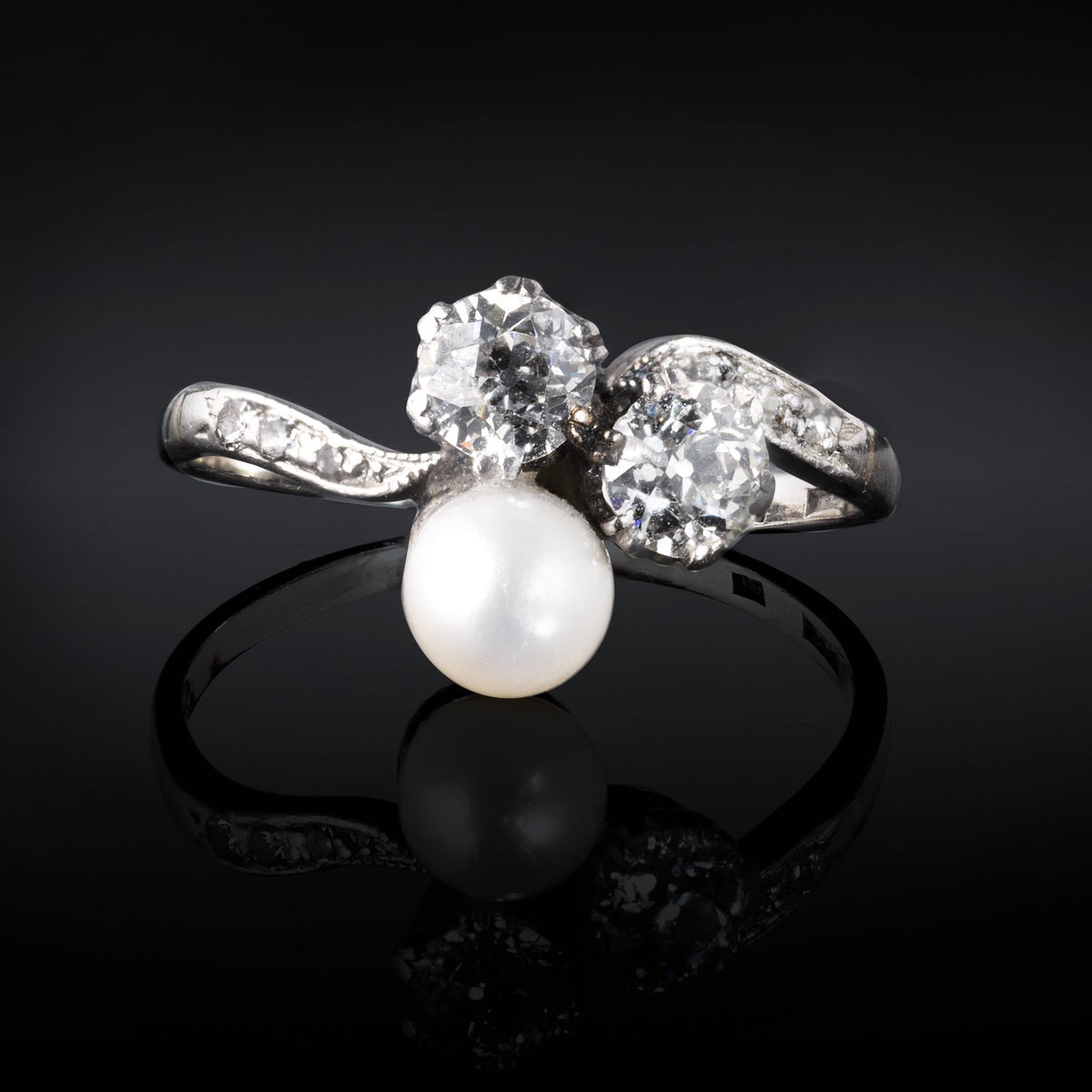 Vintage trilogy ring with two old cut diamonds and central pearl in platinum and gold setting