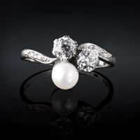 Vintage trilogy ring with two old cut diamonds and central pearl in platinum and gold setting