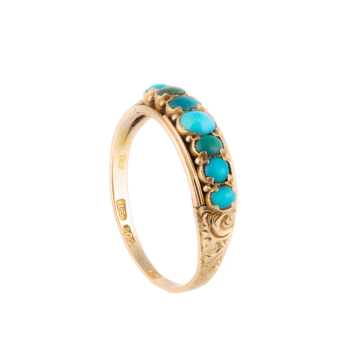 Close-up of engraved gold band and claw-set turquoise stones
