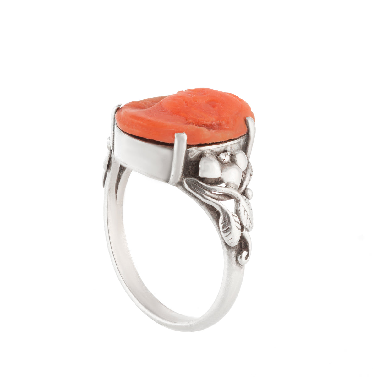 Antique handmade silver ring featuring an orange coral carved face and foliate shoulders, UK size O.
