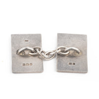 Pair of British silver cufflinks with black enamel scallop pattern, hallmarked Birmingham 1995.