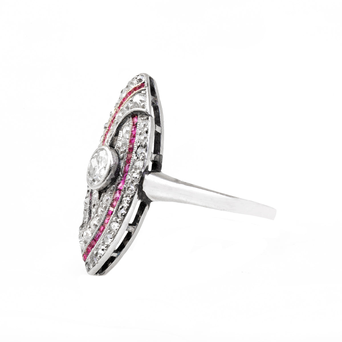 Angled side view of an Art Deco platinum ring with rubies and diamonds, highlighting low profile setting and detailed craftsmanship.