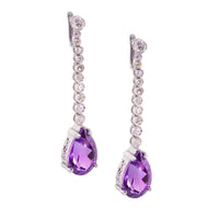 Front view of platinum Art Deco drop earrings with pear-shaped amethysts and a line of old cut diamonds.