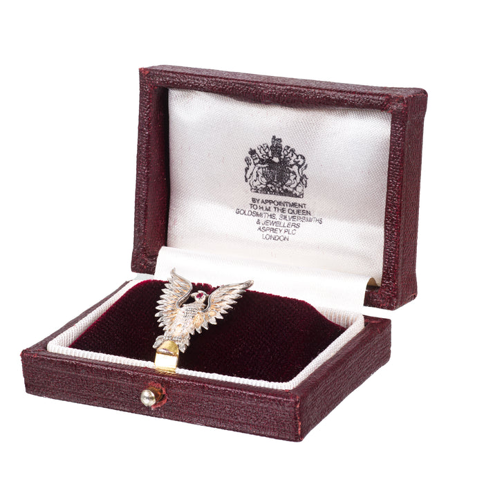 Asprey 1950s eagle pin displayed in original burgundy Asprey box with royal warrant, featuring ruby eye and gold wings