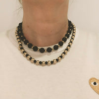 Italian mid-century onyx and gold necklace worn at the collarbone, showing elegant fit and chic style