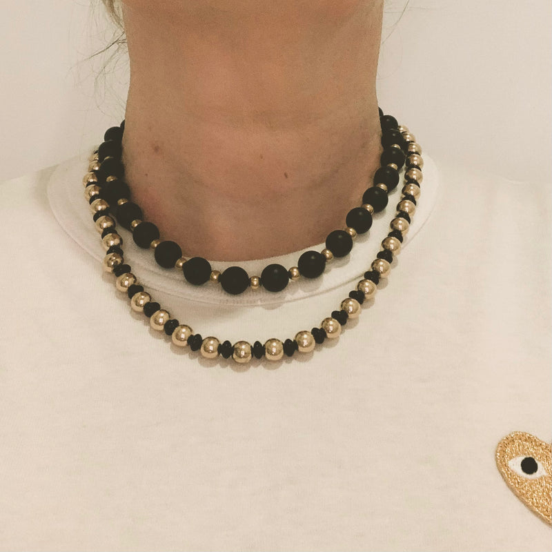 Italian mid-century onyx and gold necklace worn at the collarbone, showing elegant fit and chic style