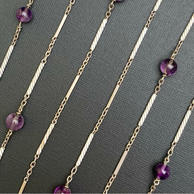 Close-up view of twisted sterling silver bar links and polished amethyst beads in a 148cm antique necklace