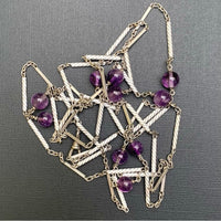 Detailed flat lay showing the interwoven silver chain and amethyst beadwork of a long Edwardian necklace