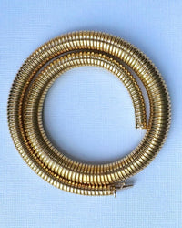 Coiled Tubogas necklace showing flexible engineering and lustrous gold finish