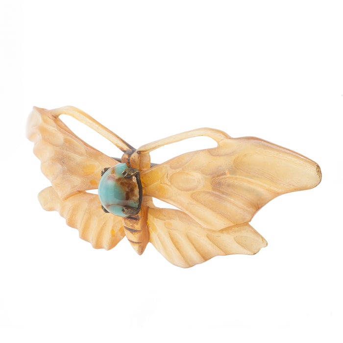 Close-up of antique horn and turquoise moth brooch, showing hand-carved wing detail