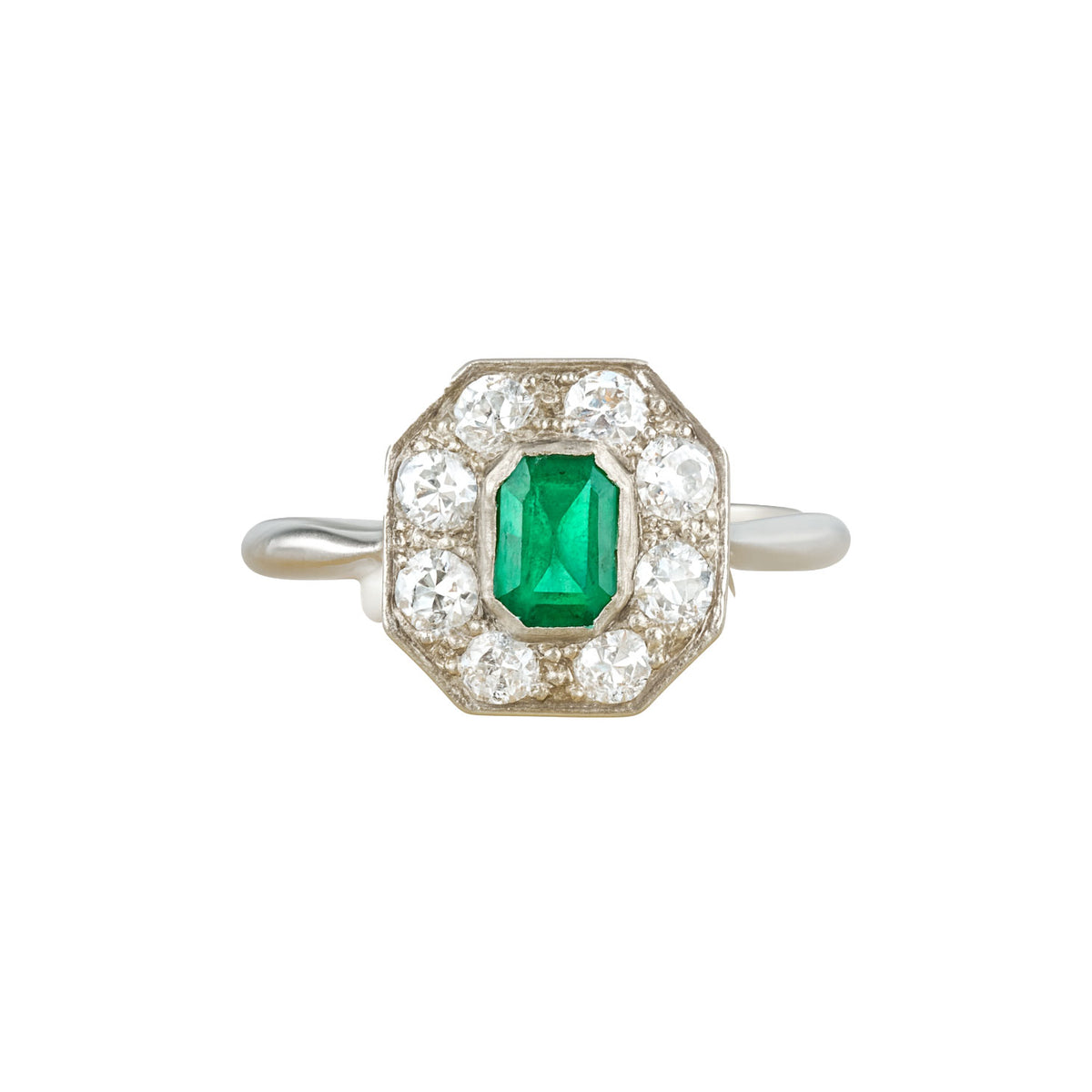 Art Deco emerald and diamond platinum ring from the 1930s, featuring an octagonal halo with old cut diamonds and a central step cut emerald.