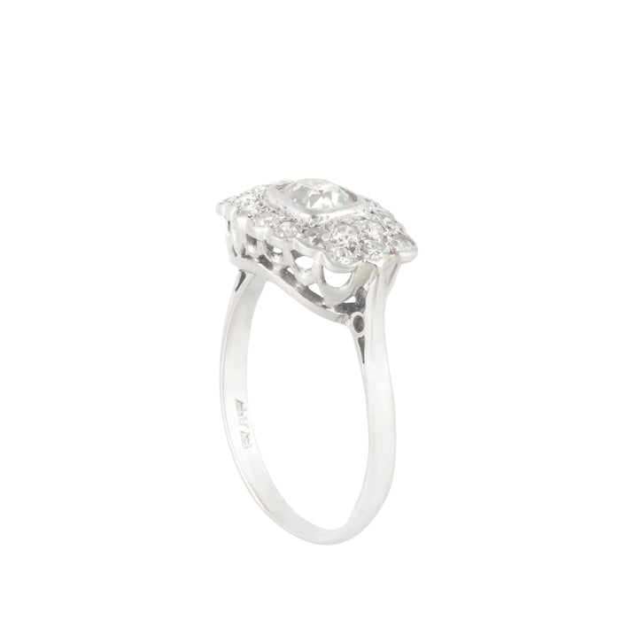 Side profile of 1940s platinum diamond cluster ring showing openwork under-gallery and scalloped diamond set edge.