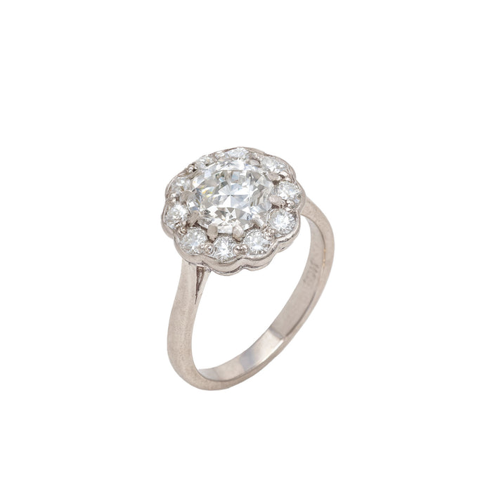 Side profile of Swiss 1981 diamond cluster ring in 18ct white gold with scalloped setting and brilliant cut diamond halo.