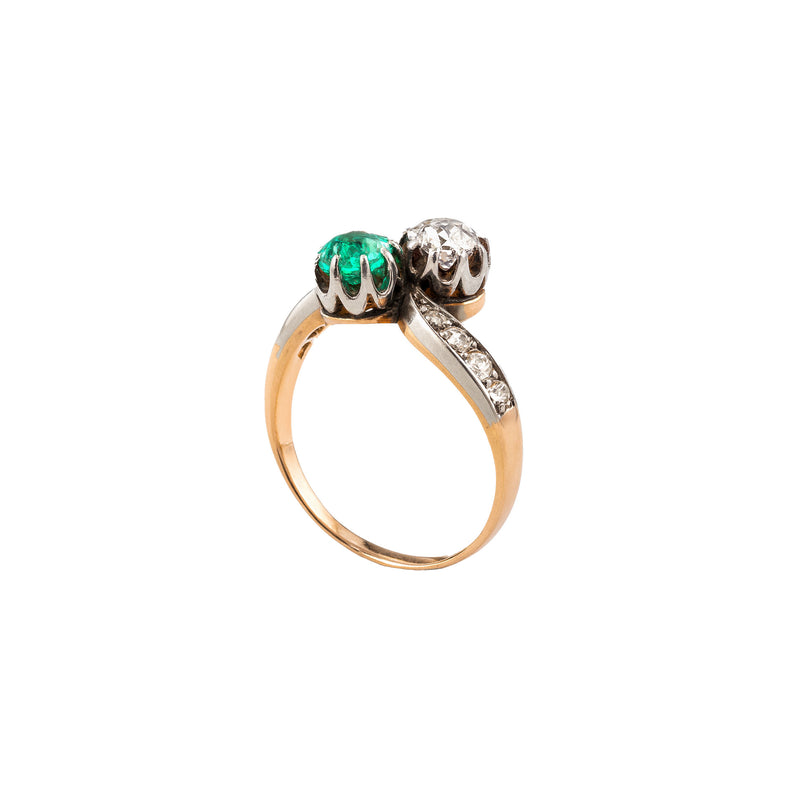 Side profile of Edwardian emerald and diamond toi et moi ring with platinum settings on 18ct gold band, c.1900.