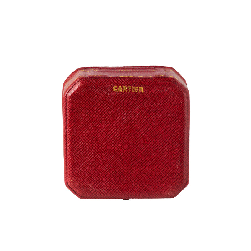 Red 1930s Cartier box with gold logo, octagonal shape.