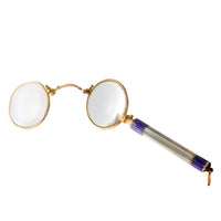 Open antique lorgnettes showing dual round lenses and ornate handle