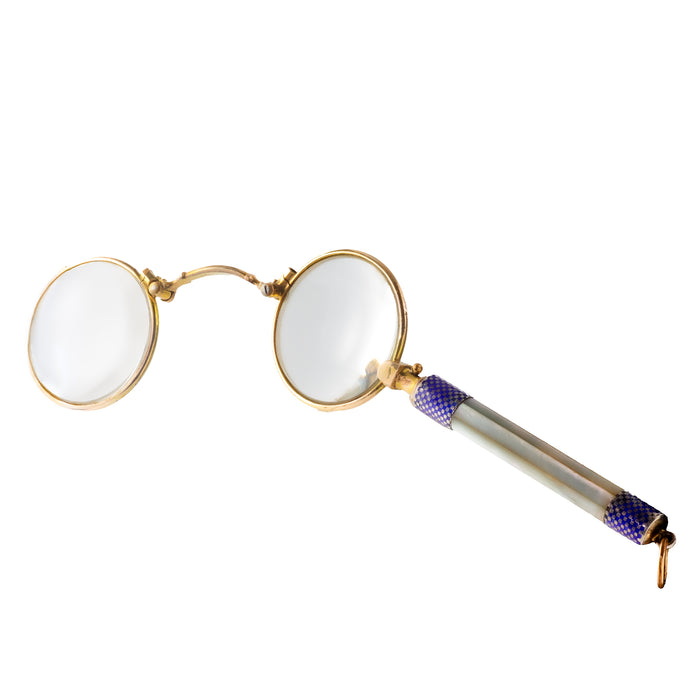 Open antique lorgnettes showing dual round lenses and ornate handle