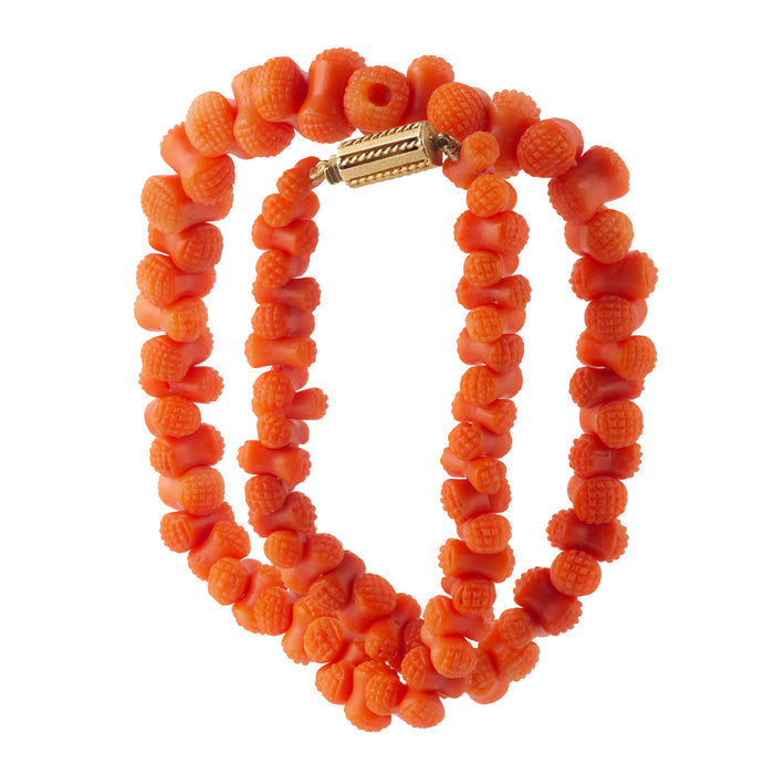 Side view highlighting coral texture and 18ct gold clasp craftsmanship