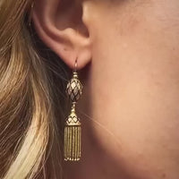 Antique French gold tassel earring with cobalt blue enamel detail, worn on ear; c.1880, 18ct yellow gold with fine chain fringe.