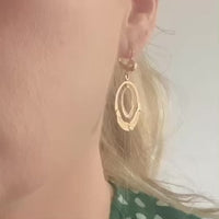 Model wearing antique Italian double-hoop earrings with hand-engraved botanical motifs in yellow and white gold