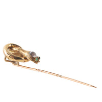 Side view of Victorian gold snake tiepin with coiled body, clear paste head, and green paste eyes, c.1880s.